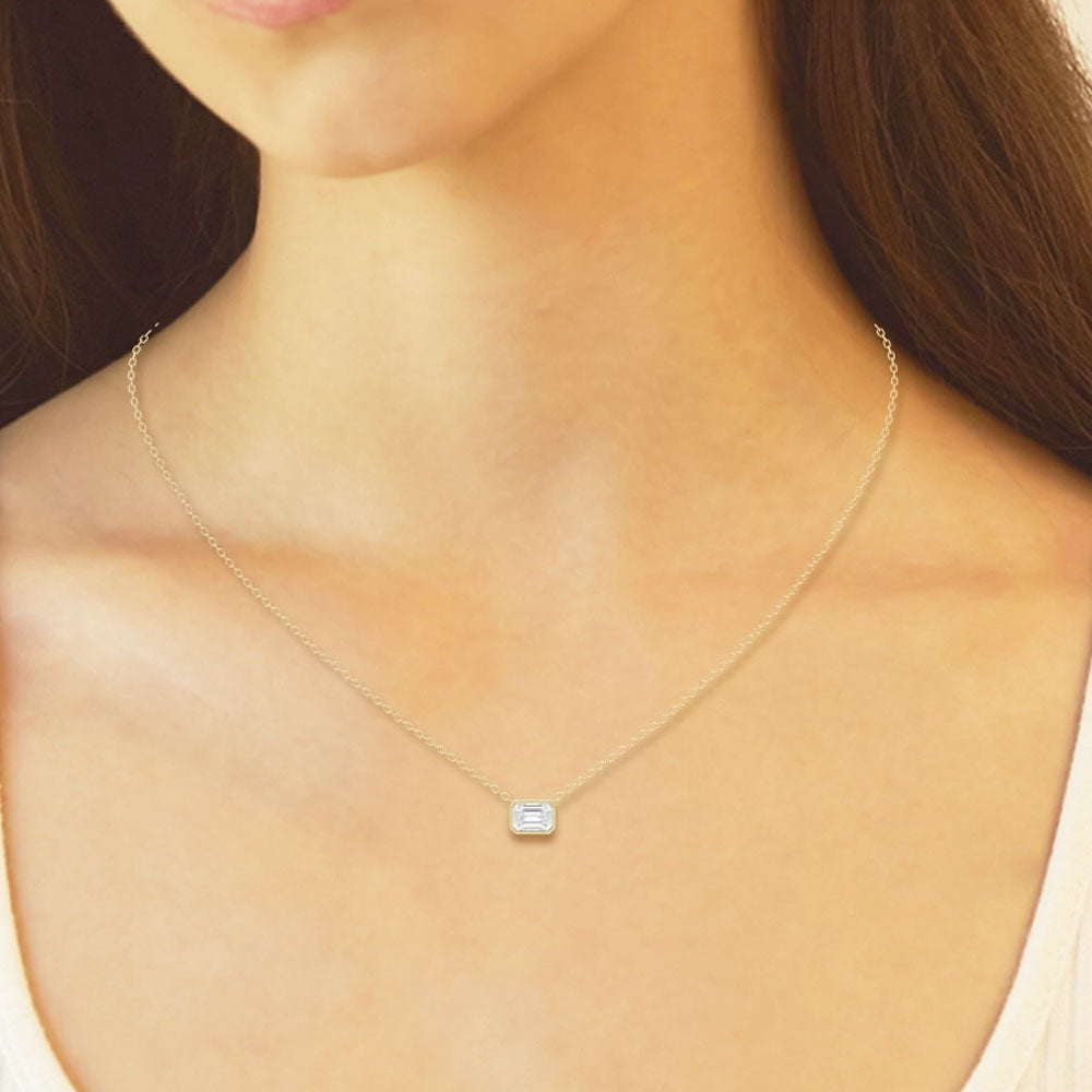 Front view of Puro Emerald Solitaire Diamond Pendant with yellow gold chain on model.