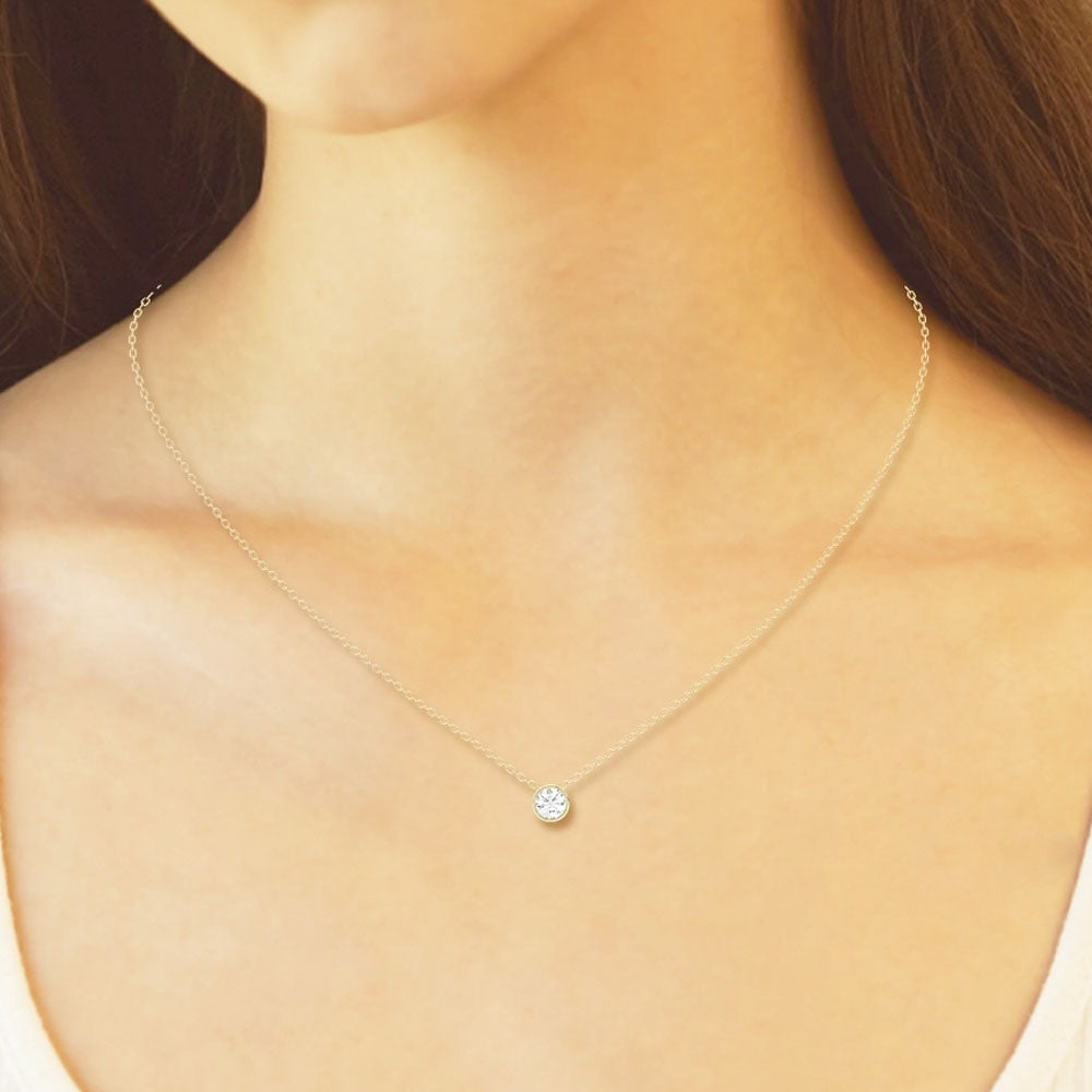 Front view of Puro Round Bezel Diamond Pendant with yellow gold chain on model.