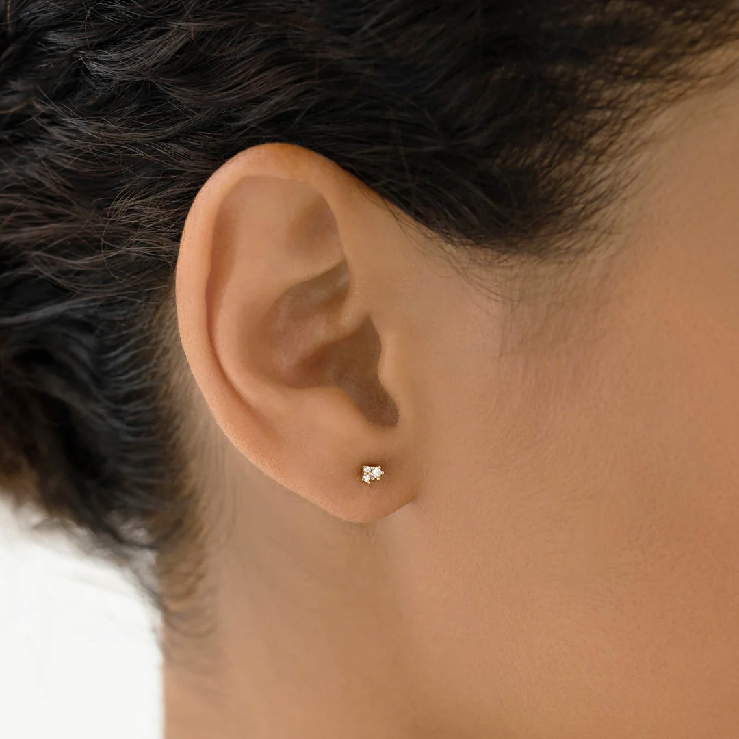 Puro mini cluster stud earrings in yellow gold on model. 